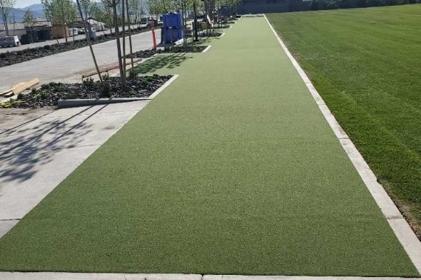 Toronto Outdoor tee line consisting of one continuous green synthetic grass strip surrounded by trees